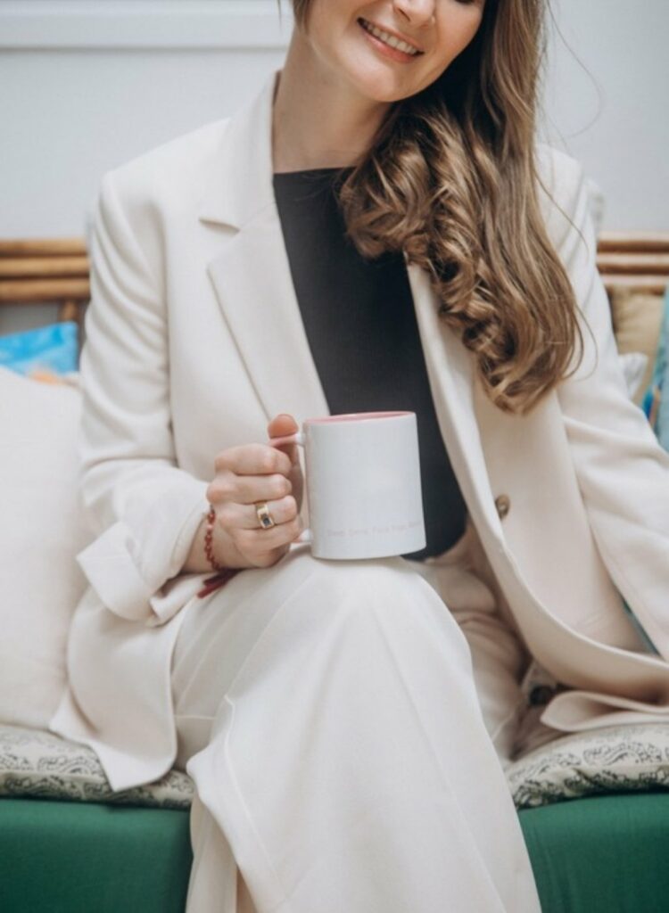Femme détendue sur un canapé, une tasse à la main